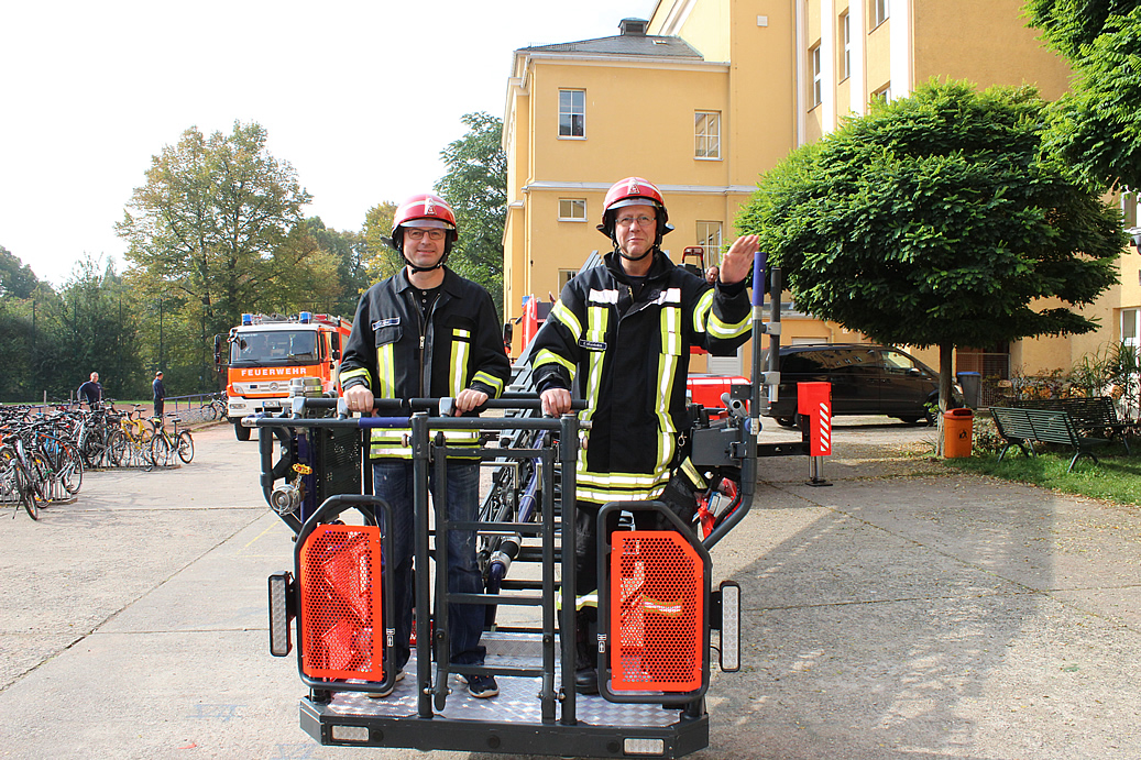 Kein bisschen blass, den Mageninhalt noch in sich tragend, landet Herr Scholz in Feuerwehrkluft wieder sicher im Schulhof.